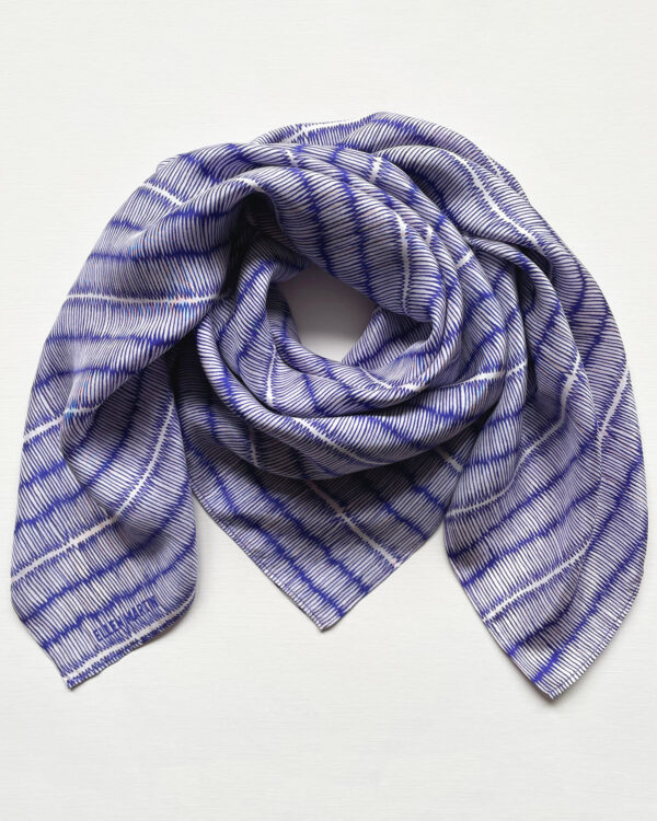 Large square silk scarf with intricate repeat pattern in blue and off-white.