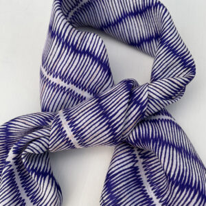 Small square silk scarf with intricate repeat pattern in blue and off-white.