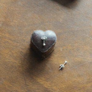 silver studs on a vintage heart shaped box on a wooden surface