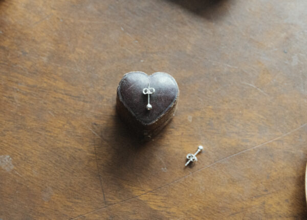 silver studs on a vintage heart shaped box on a wooden surface