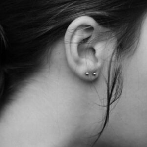 Close up of studs on a womans ear in black and white