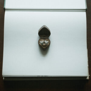 Heart studs displayed in a vintage jewellery box flat lay on a book page