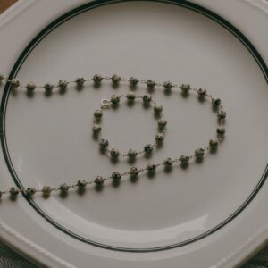 beaded collar and braclet displayed on a classic cream dinner plate