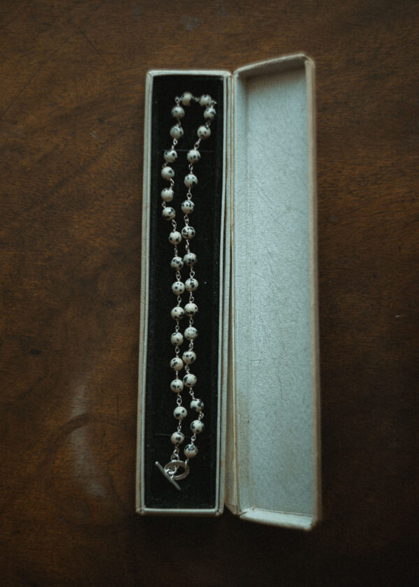 beaded necklace displayed in a vintage jewellery box on a wooden surface
