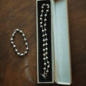 beaded bracelet and collar on wooden surface