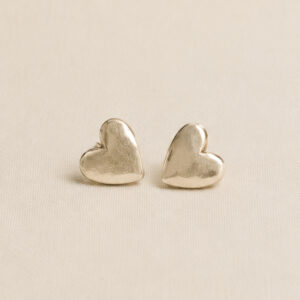 gold heart shaped studs on a plain backgrpund